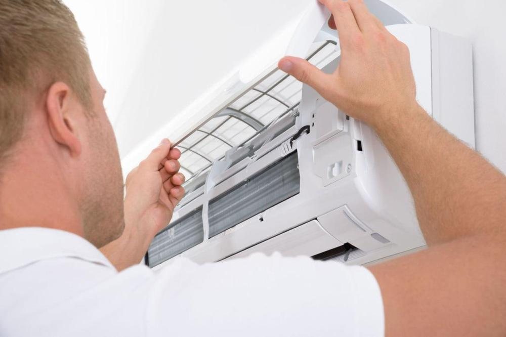 Technicien qui entretient une climatisation murale
