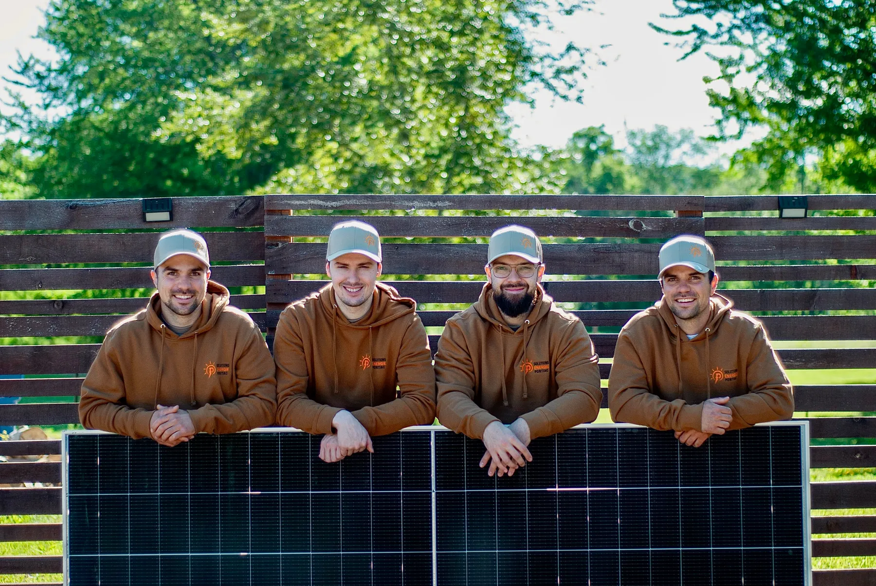 Les quatre associés de Solutions Énergie Pontiac devant des panneaux solaires