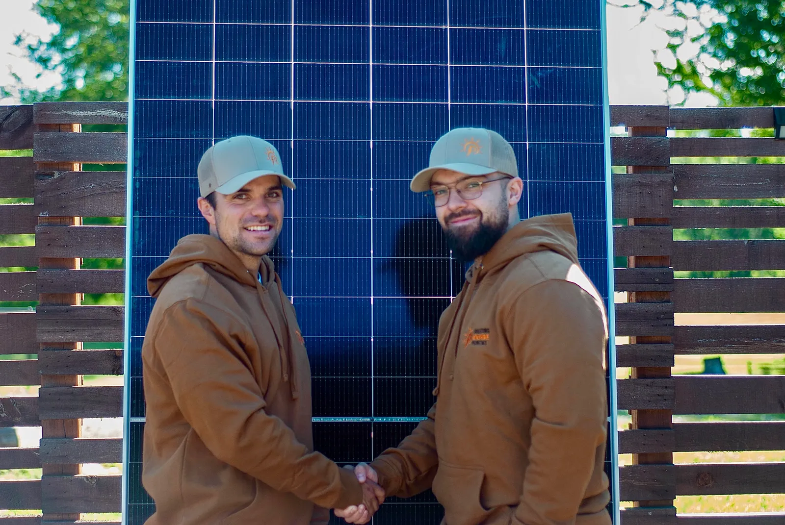 Deux associés de SEP se serrant la main devant des panneaux solaires